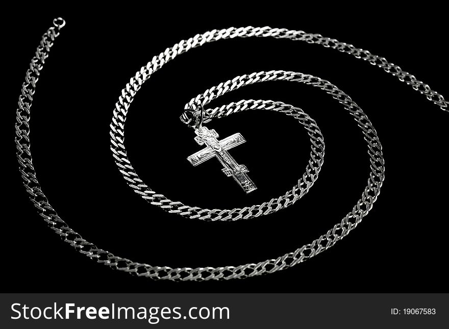 Chain and cross combined in a spiral isolated on a black background