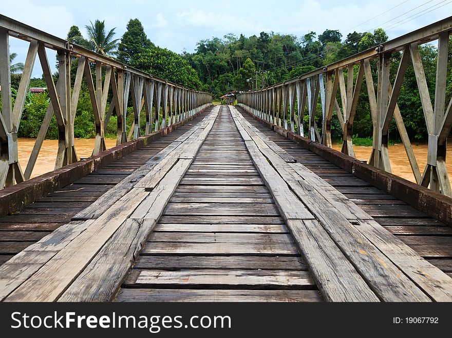 Old bridge over a brown river in the amazon