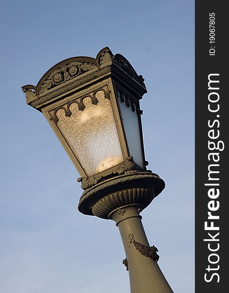 Old street lamp against blue sky