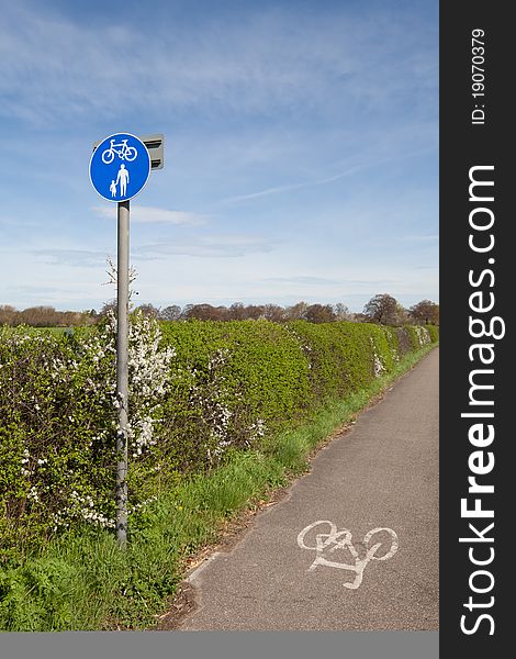 Cycle lane with sign beside a countryside path on a bright day with blue sky and sunshine. Cycle lane with sign beside a countryside path on a bright day with blue sky and sunshine