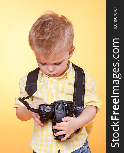 Little smiling photographer watching photo on professional camera. Little smiling photographer watching photo on professional camera