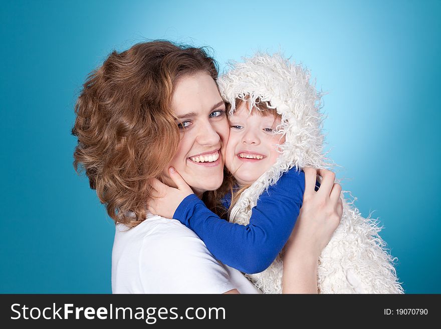 Smiling child and mom embracing, closeup portrait