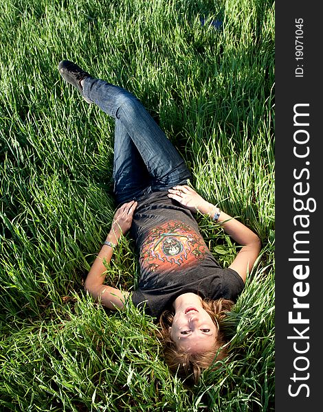 Young woman lying in green grass field. Young woman lying in green grass field