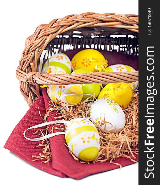 Decorated Easter wicker basket with colorful eggs on red wine napkin