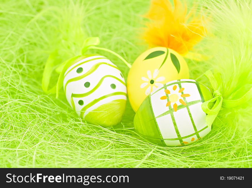 Easter composition, three brightly colored eggs, green background. Easter composition, three brightly colored eggs, green background.