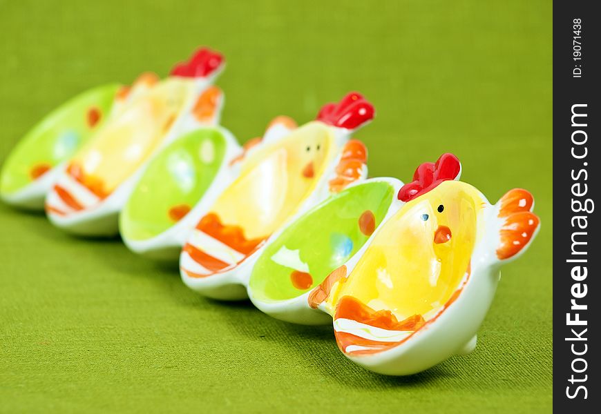 Colorful Easter eggs holder on a green flax background