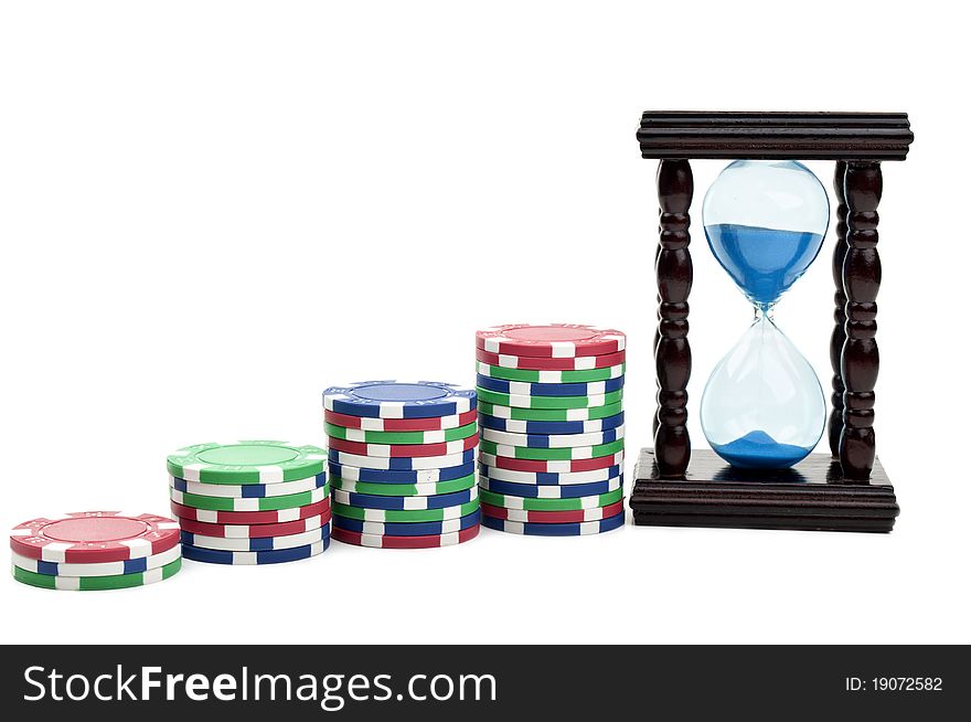 Hourglass and poker chips isolated on a white background