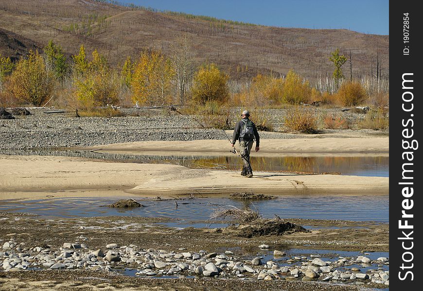 Fishing - fisherman walking to river