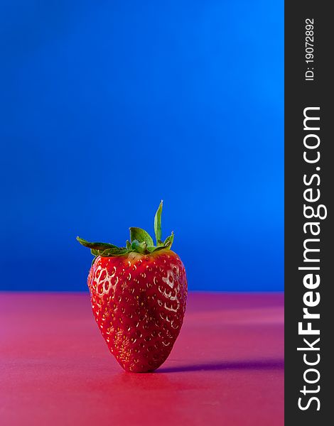 A strawberry on blue background isolated