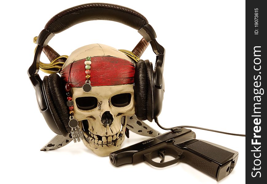 Skull in ear-phones with a lying pistol are isolated on a white background