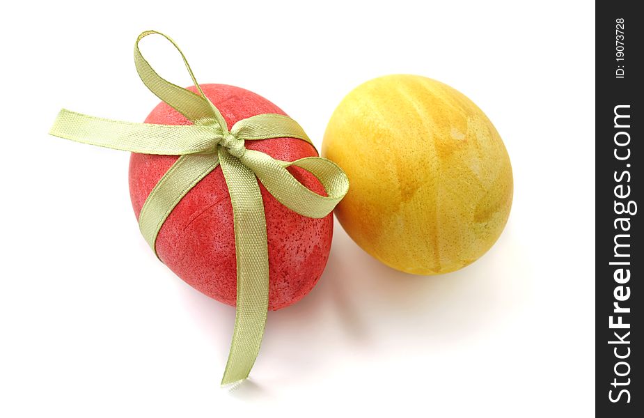Red and yellow eggs with a bow on a white background. Red and yellow eggs with a bow on a white background