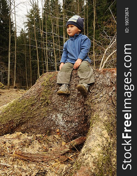 Little child sitting on a tree stump and having rest. Little child sitting on a tree stump and having rest