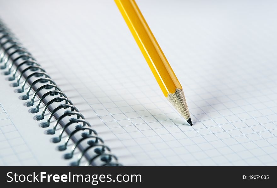 Yellow pencil on blank notebook with spiral