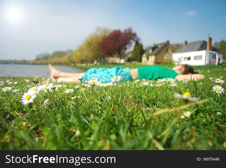 Young girl sleeping on grass near lake and caravan. Young girl sleeping on grass near lake and caravan