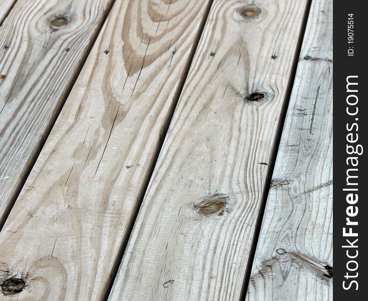 Weathered wooden planks with knot holes and tool marks visible. Weathered wooden planks with knot holes and tool marks visible