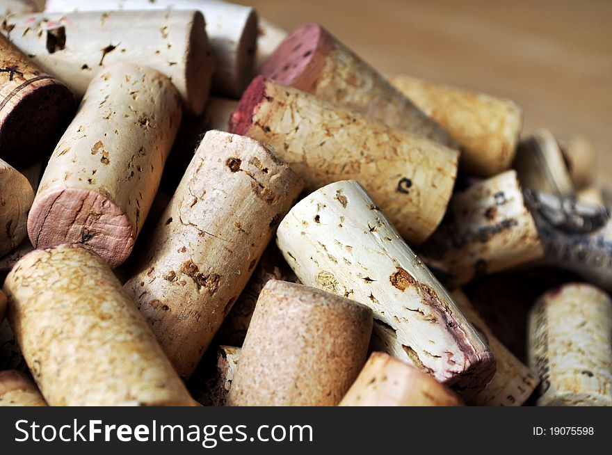 Unlabeled corks fill the image with maple wood in the background. Unlabeled corks fill the image with maple wood in the background