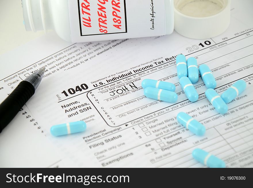 Stock photo of IRS 1040 form with aspirin and a pen with John written in so far. Stock photo of IRS 1040 form with aspirin and a pen with John written in so far.