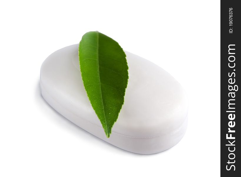 White soap bar with green leaf isolated on white background.