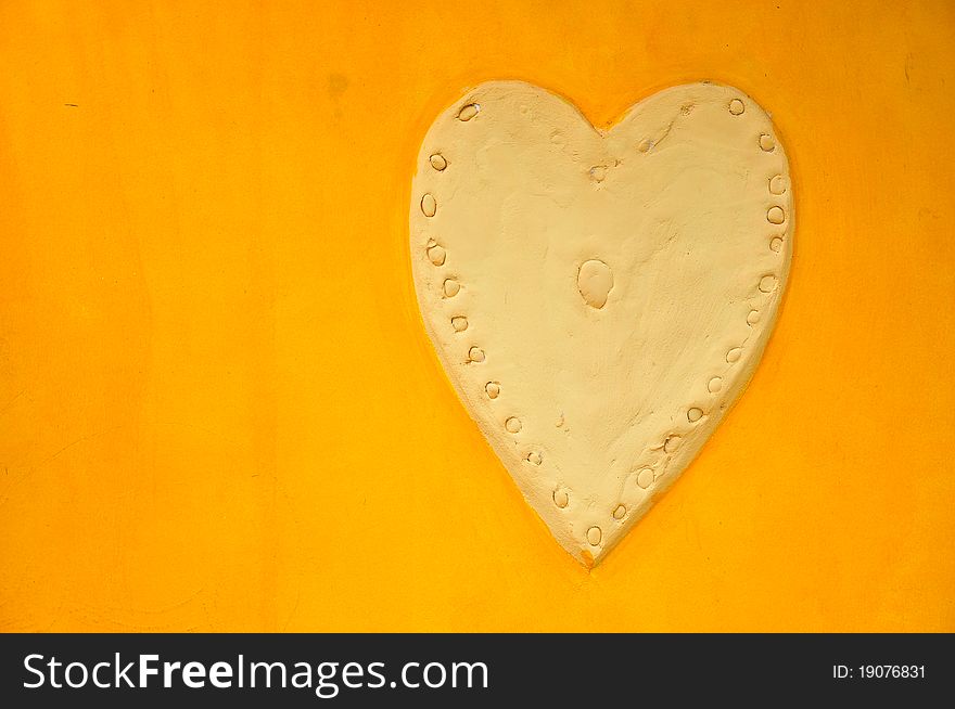 ฺBig Heart Stucco on Plain Yellow Wall. ฺBig Heart Stucco on Plain Yellow Wall