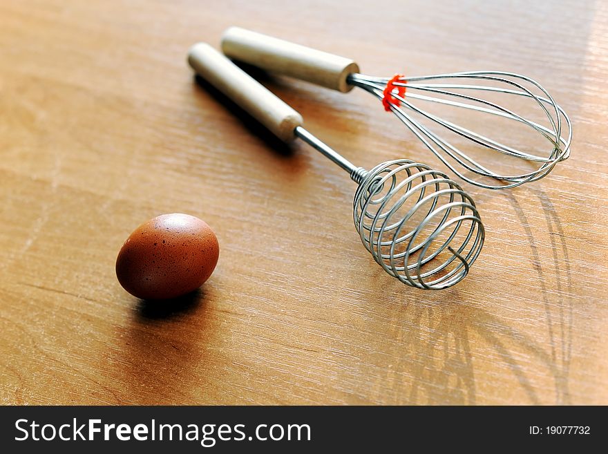 An image of an egg and whisks on the table