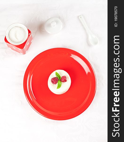 Decorated ricotta dessert over red plate. Decorated ricotta dessert over red plate