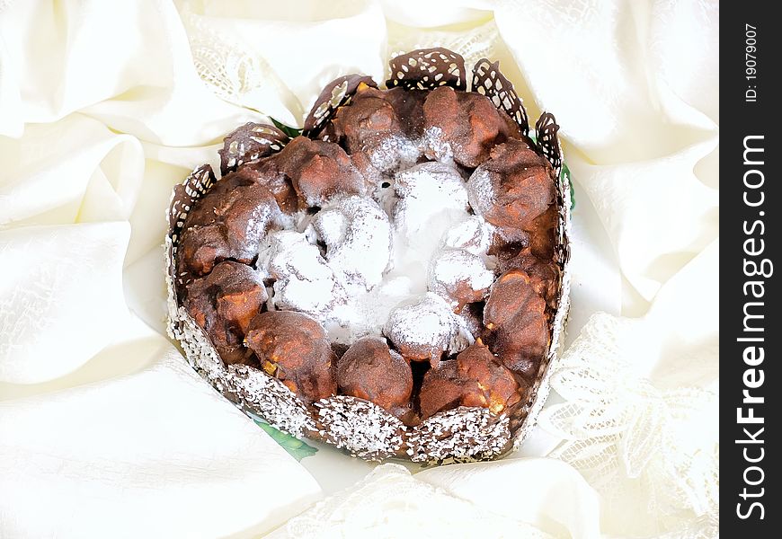 Beautiful heart shaped cake made from profiteroles decorated with chocolate and coconut chips