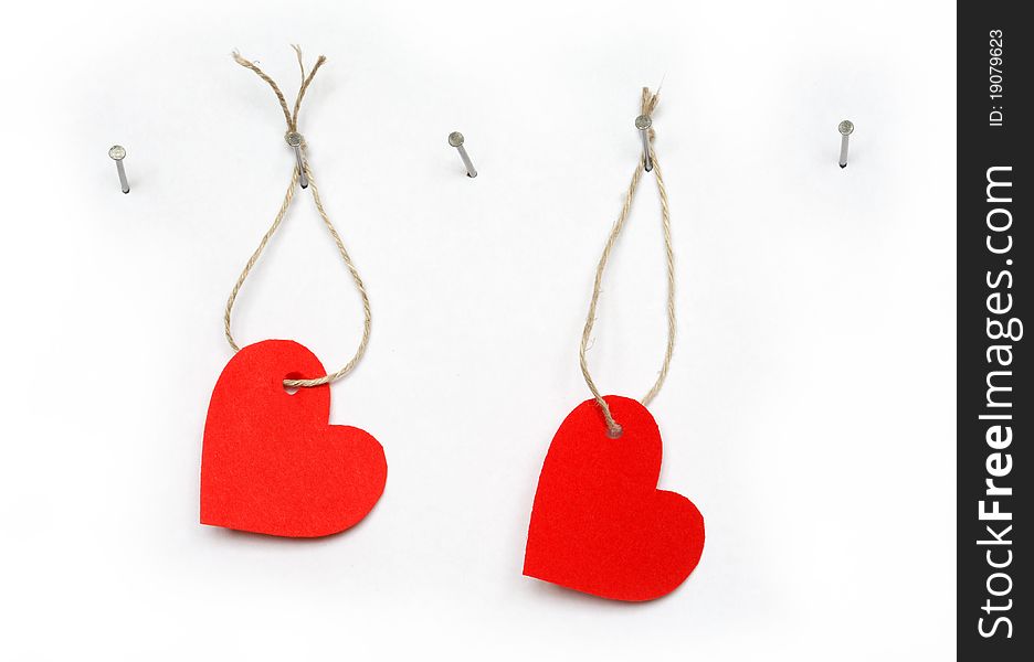 Red paper hearts hanging on white background with rope and nail. Red paper hearts hanging on white background with rope and nail