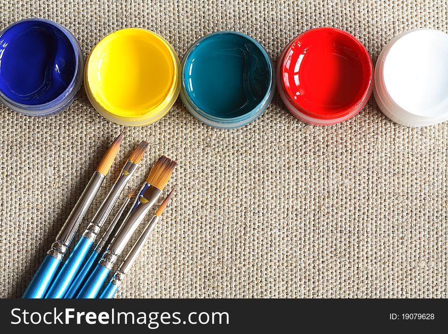 Set of paintbrushes and paint on canvas background. Set of paintbrushes and paint on canvas background