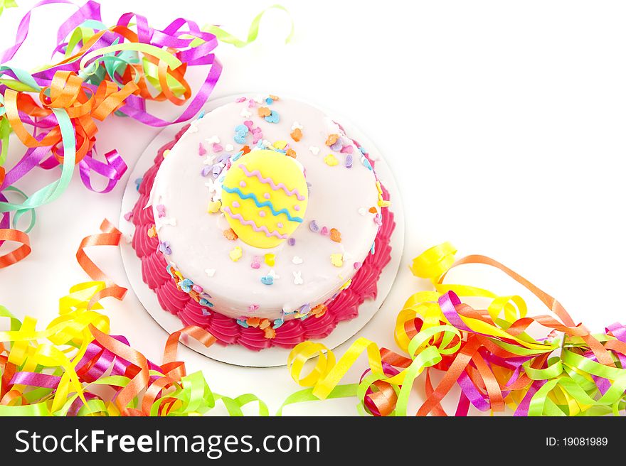 A bright colored Easter Cake with colorful party ribbons, white background