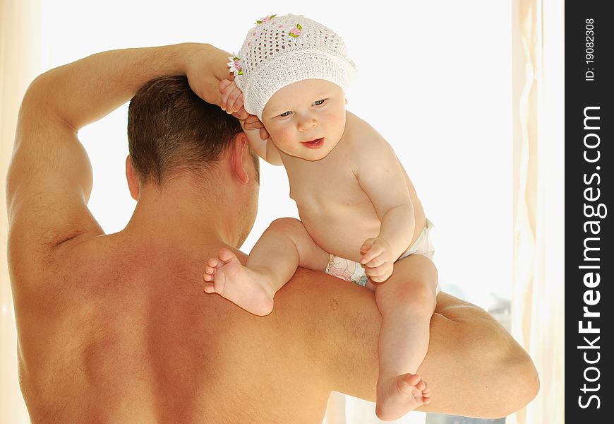 The young man holds a small daughter on a shoulder. The young man holds a small daughter on a shoulder