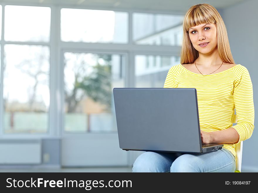 Casual girl sitting on the chair with notebook. Casual girl sitting on the chair with notebook