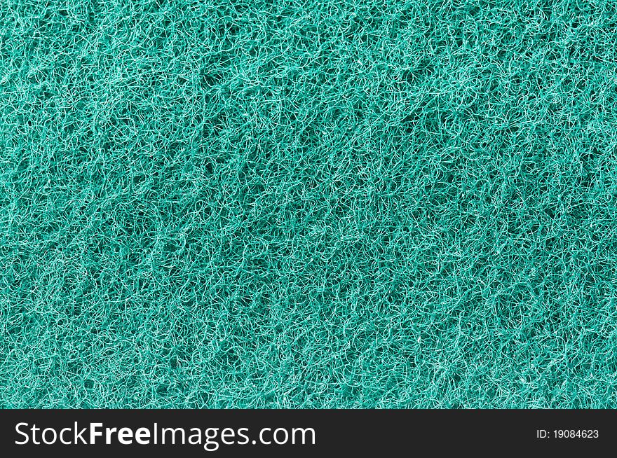 Close-up of a green cleaning sponge surface as a backdrop