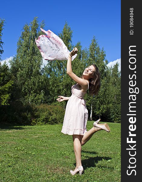 Beautiful young woman dancing with kerchief against the blue sky. Beautiful young woman dancing with kerchief against the blue sky