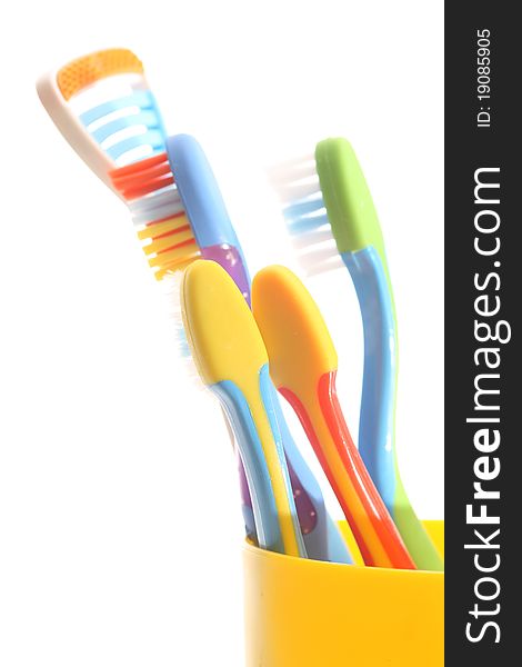 Toothbrushes in a yellow glass