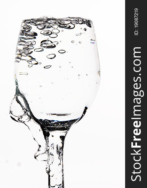 Glass and water on white background