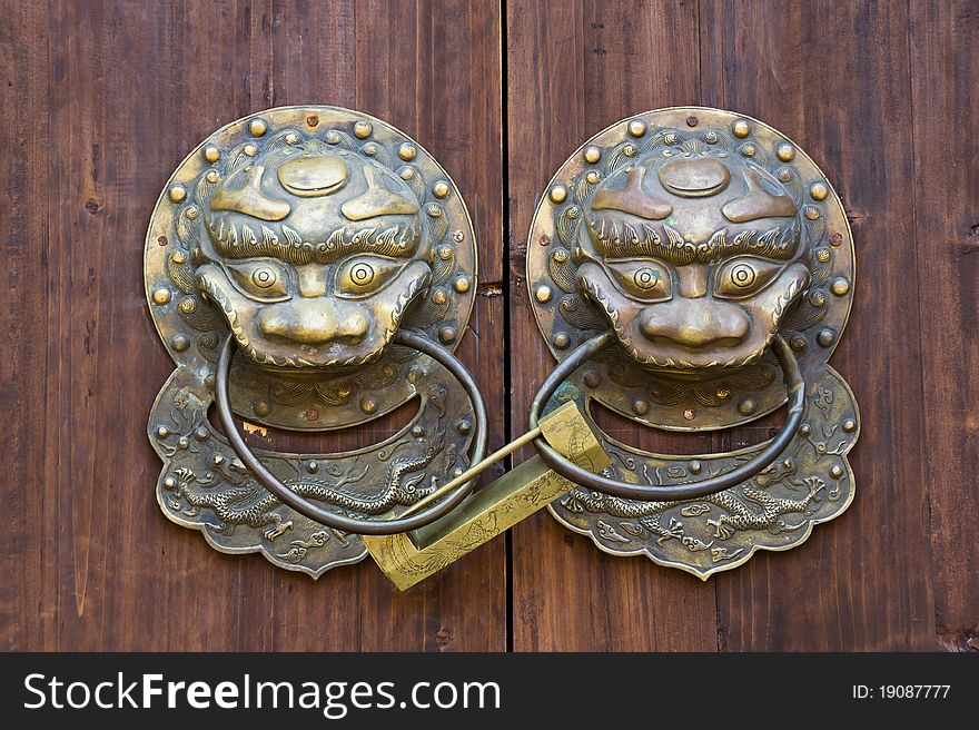 Chinese traditional lion knocker and phoenix lock on the door. Chinese believe these mythological beast can be protect their family and property. Chinese traditional lion knocker and phoenix lock on the door. Chinese believe these mythological beast can be protect their family and property.