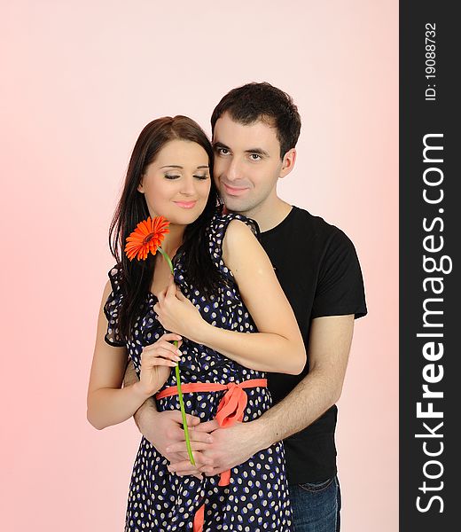 Lovely romantic couple with flower embracing