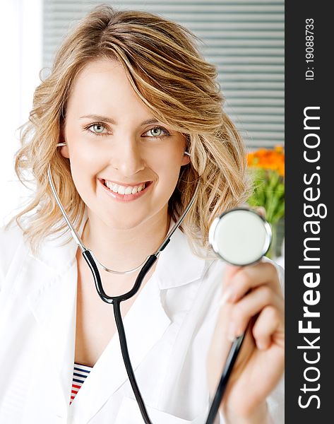 Close-up of beautiful blonde female doctor with stethoscope, smiling at camera. Close-up of beautiful blonde female doctor with stethoscope, smiling at camera