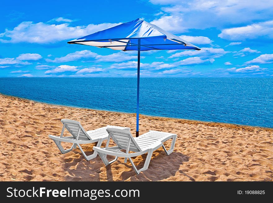 Beach with chaise lounges and umbrella