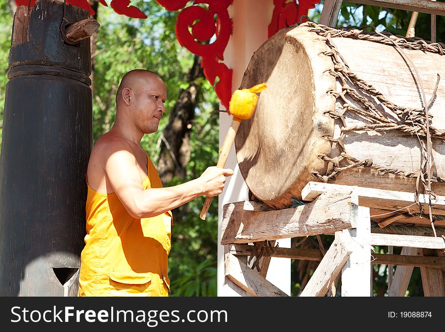 Buddhist monk, hitting the drum in the temple