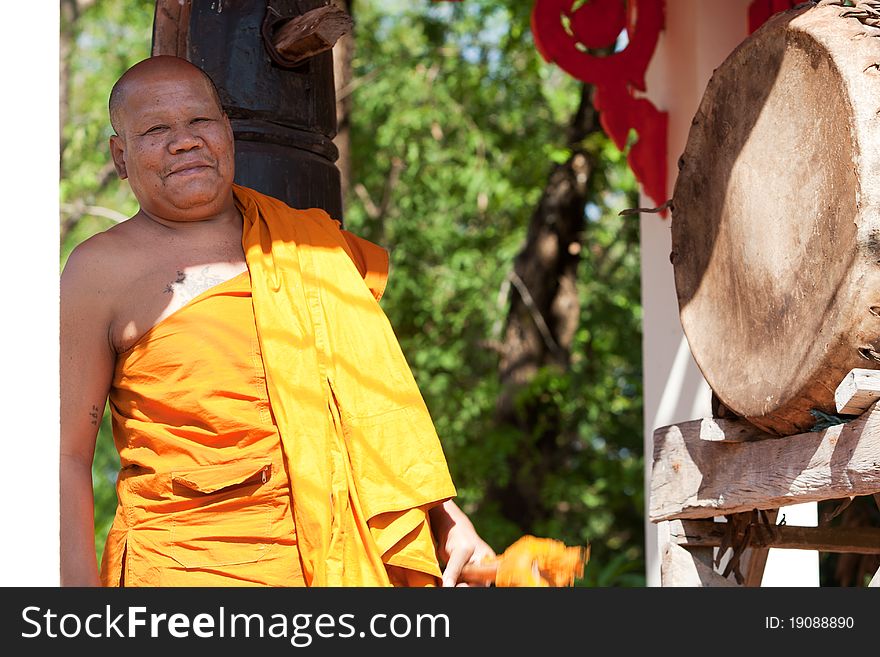 Buddhist monk, hitting the drum in the temple