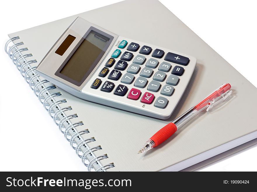 Calculator with book and pen on white background