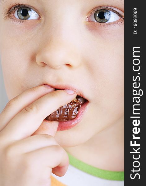 Close Up Of Young Boy Eating A Chocolate