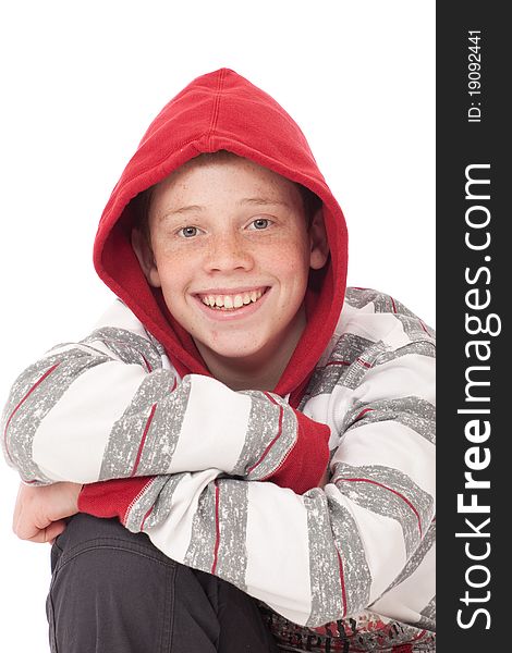 Young teenage boy kneeling with crossed arms and red hood. Young teenage boy kneeling with crossed arms and red hood