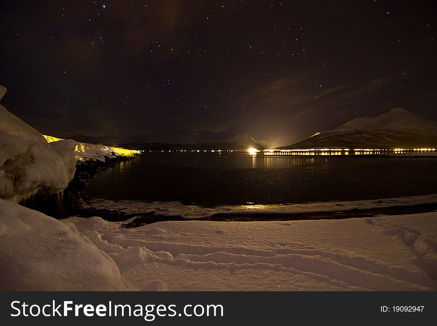 Weak aurora northern light over the winter sea at Storsteinnes in North of Norway