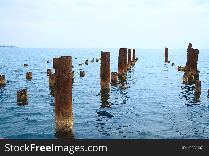 The old rusty iron bridge on sea. The old rusty iron bridge on sea