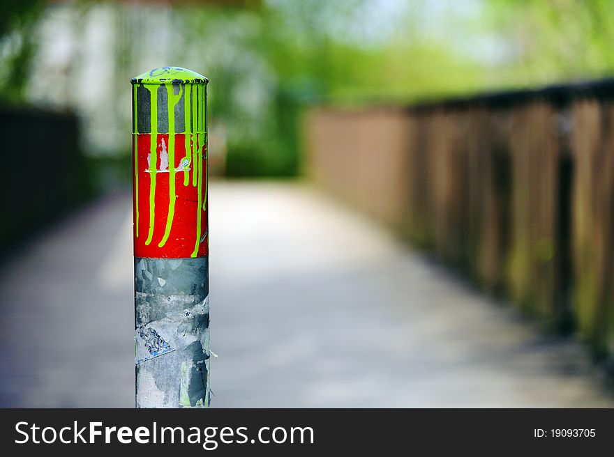 Colorful metal posts in front of a pedestrian bridge