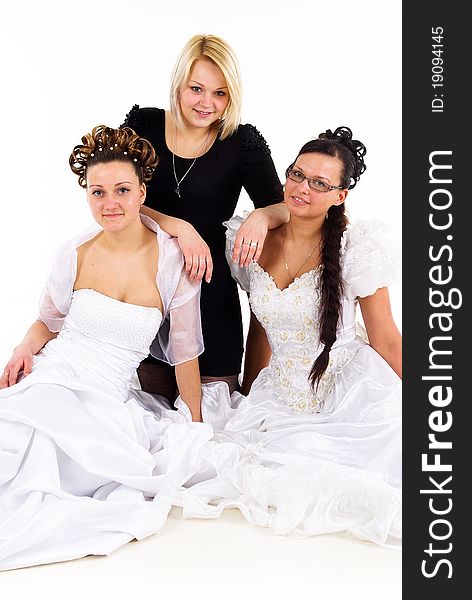 Two young beautiful brides in white dresses and their female friend - hairstylist in black dress on white isolated background. Two young beautiful brides in white dresses and their female friend - hairstylist in black dress on white isolated background.