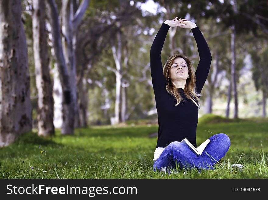 Young woman stretching on the grass