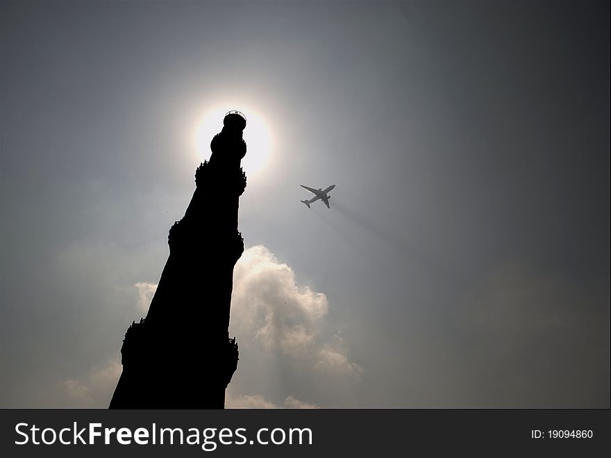 This image of Qutab Minar at Delhi was taken in strong light with an aircraft fying over it.